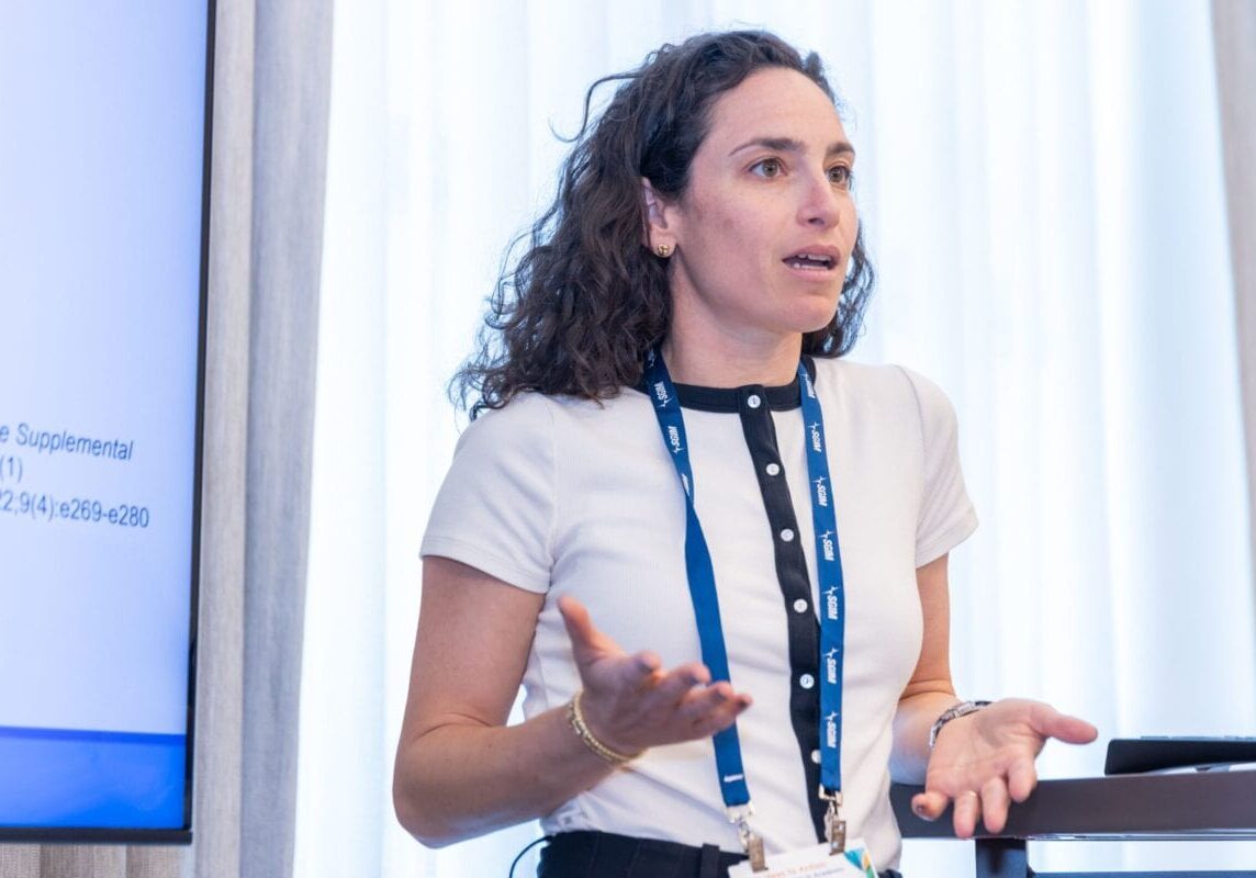 A woman giving a presentation at a conference.