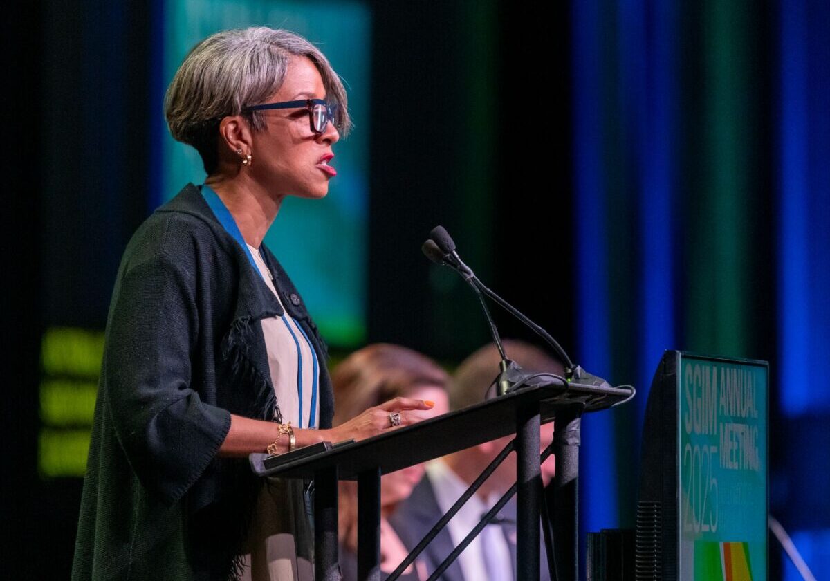 A person standing at a podium and addressing a conference audience
