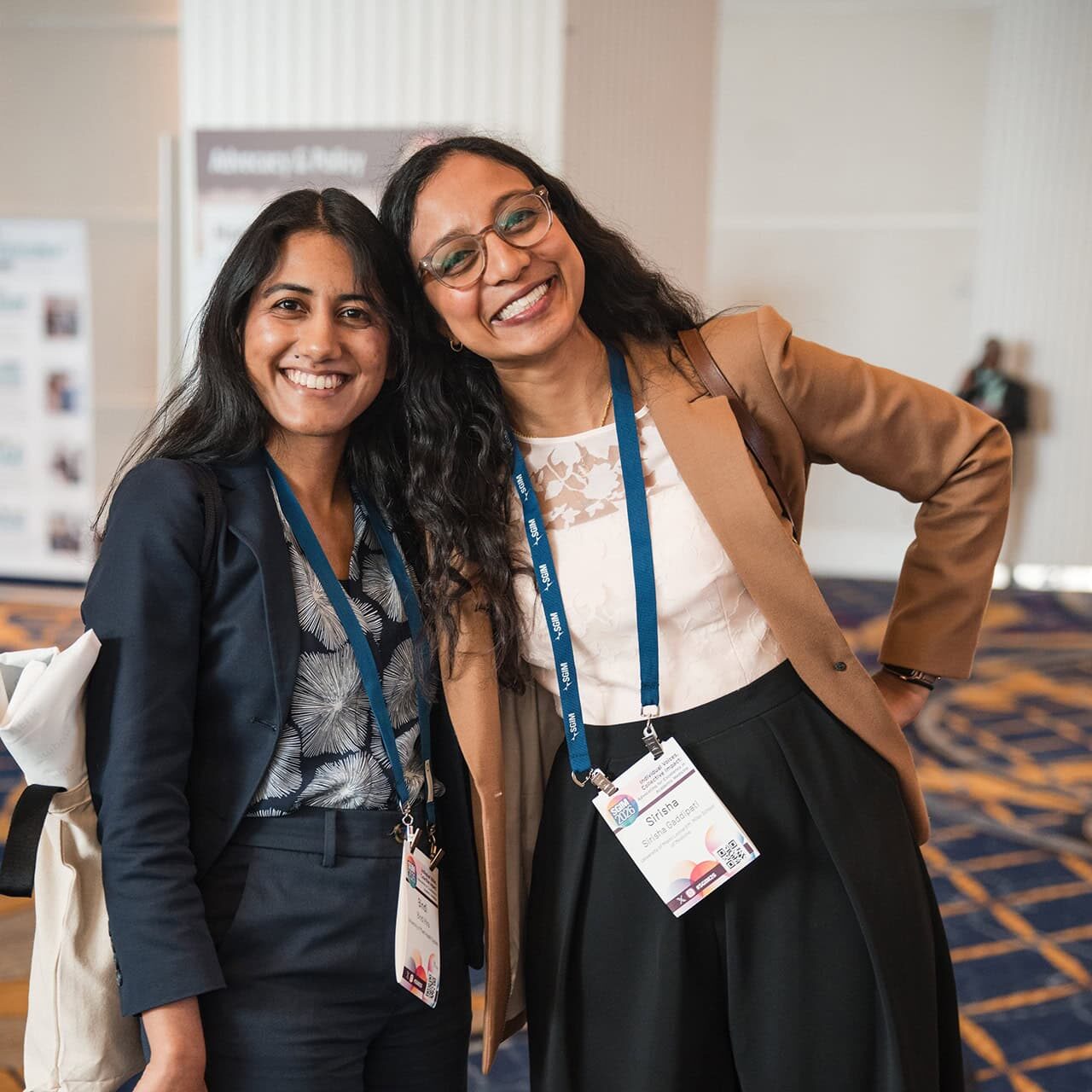 Image of two smiling meeting attendees at a poster session